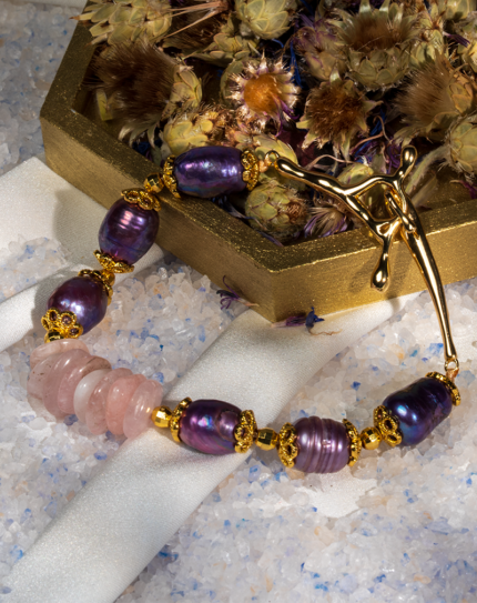 دستبند زنانه شوکا با سنگ رز کوارتز و مروارید بنفش، آویز صلیب طلایی، طراحی دست‌ساز و لوکس.