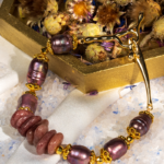 دستبند زنانه شوکا با کوارتز توت‌فرنگی و مروارید بنفش، آویز صلیب طلایی، طراحی دست‌ساز و لوکس.