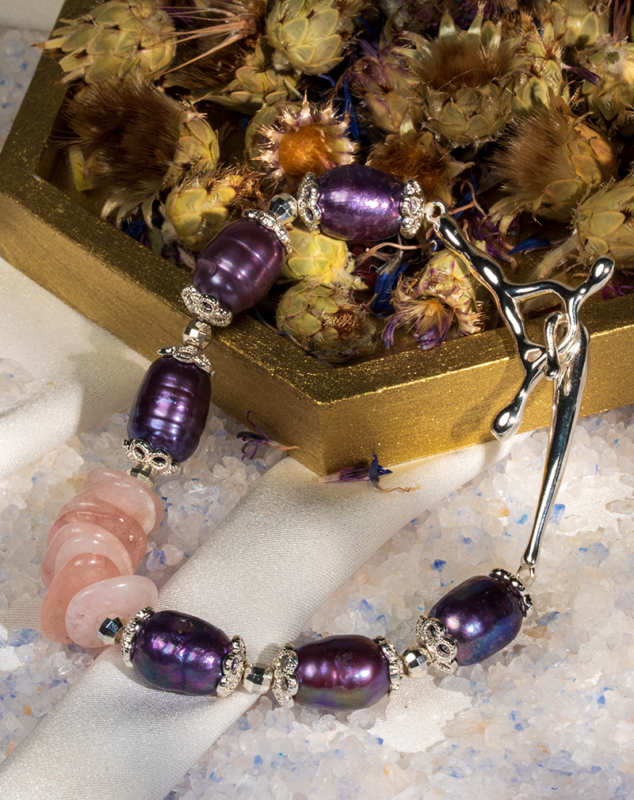 دستبند زنانه شوکا با سنگ رز کوارتز و مروارید بنفش، آویز صلیب نقره‌ای، طراحی دست‌ساز و خاص.