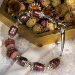 دستبند زنانه شوکا با کوارتز توت‌فرنگی و مروارید بنفش، آویز صلیب نقره‌ای، طراحی دست‌ساز و خاص.