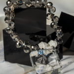 دستبند زنانه شوکا با سنگ هائولیت سفید و کریستال دودی، آویز پاپیون مشکی؛ طراحی فشن و دست‌ساز.