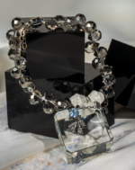 دستبند زنانه شوکا با سنگ هائولیت سفید و کریستال دودی، آویز پاپیون مشکی؛ طراحی فشن و دست‌ساز.