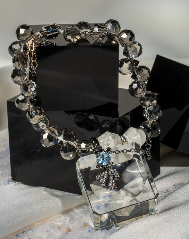 دستبند زنانه شوکا با سنگ هائولیت سفید و کریستال دودی، آویز پاپیون مشکی؛ طراحی فشن و دست‌ساز.