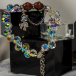 دستبند زنانه شوکا با کوارتز توت‌فرنگی و کریستال رنگین‌کمانی، آویز پاپیون نقره‌ای، طراحی دست‌ساز و درخشان.