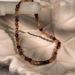 دستبند زنانه شوکا با سنگ طورمالین صورتی و گوی‌های طلایی، طراحی مینیمال و لطیف دارد و برای استفاده روزمره و استایل‌های زنانه بسیار مناسب است.