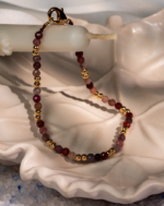 دستبند زنانه شوکا با سنگ طورمالین صورتی و گوی‌های طلایی، طراحی مینیمال و لطیف دارد و برای استفاده روزمره و استایل‌های زنانه بسیار مناسب است.