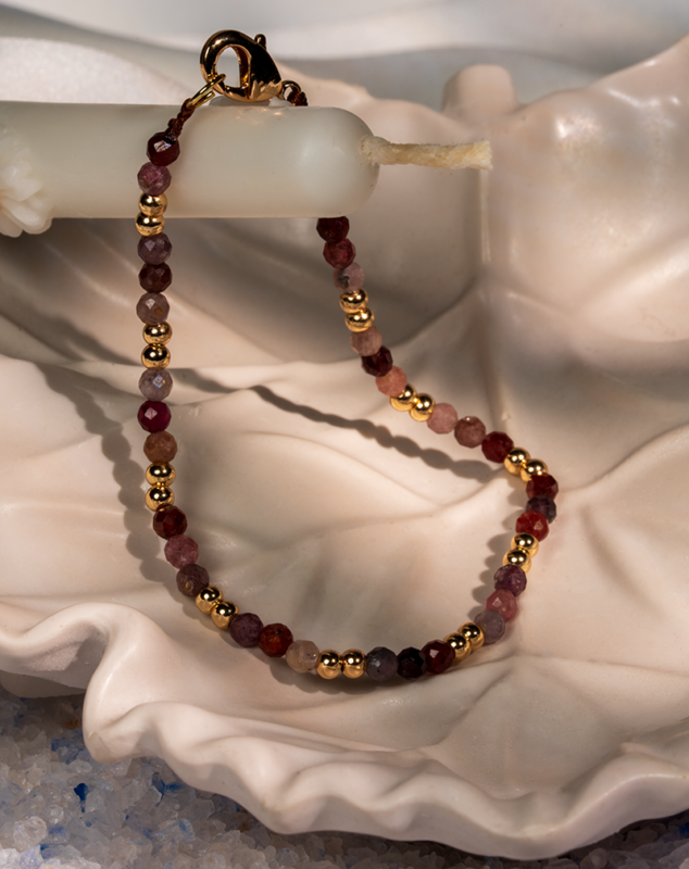 دستبند زنانه شوکا با سنگ طورمالین صورتی و گوی‌های طلایی، طراحی مینیمال و لطیف دارد و برای استفاده روزمره و استایل‌های زنانه بسیار مناسب است.