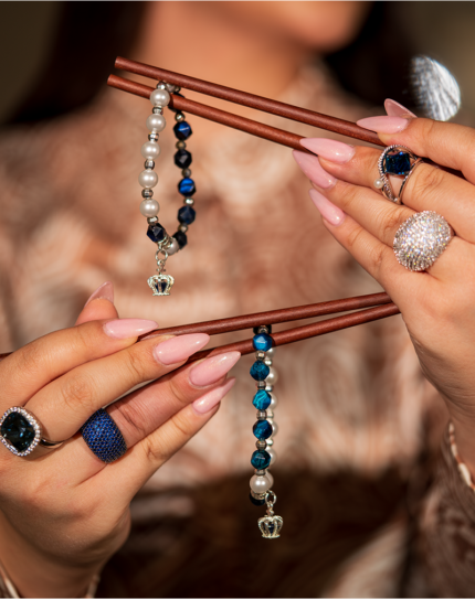 خرید دستبند زنانه شوکا با سنستیک آبی، مروارید سفید و آویز تاج نقره‌ای، طراحی شیک و دست‌ساز.