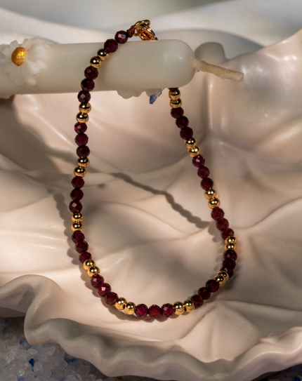 دستبند زنانه شوکا با سنگ گارنت زرشکی و گوی‌های طلایی، مینیمال و لوکس.