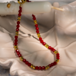 دستبند زنانه شوکا با مهره‌های قرمز و گوی‌های طلایی، طراحی مینیمال و چشم‌گیر دارد و مناسب استایل‌های جسور و خاص است.