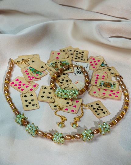 خرید ست مروارید طلایی شوکا شامل گردنبند، دستبند و گوشواره با ترکیب مروارید طلایی، مهره‌های سبز و قهوه‌ای. ست دست‌ساز لوکس مناسب مهمانی و استایل خاص.