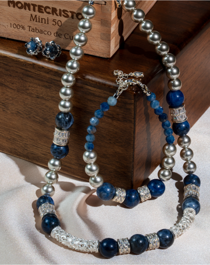 ست زیورآلات زنانه شوکا شامل گردنبند، دستبند و گوشواره با سنگ سودالیت طبیعی و مروارید نقره‌ای. طراحی لوکس با ترکیب رنگ آبی و سرمه‌ای مناسب استایل‌های شیک.