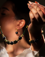 ست زیورآلات زنانه شوکا با ترکیب گلدستون سرمه‌ای و گلدستون سبز تیره همراه با جزئیات طلایی-سبز. شامل گردنبند، دستبند و گوشواره. مناسب مهمانی‌ها و استایل مجلسی.