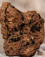 ست زیورآلات زنانه شوکا با ترکیب گلدستون سرمه‌ای و گلدستون سبز تیره همراه با جزئیات طلایی-سبز. شامل گردنبند، دستبند و گوشواره. مناسب مهمانی‌ها و استایل مجلسی.