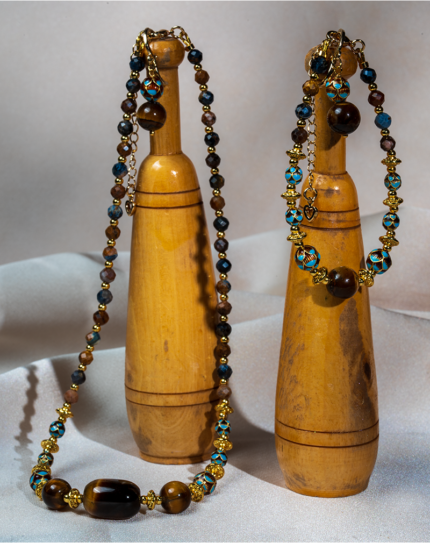 ست زیورآلات زنانه شوکا با سنگ‌های طبیعی چشم ببر و پیترسایت در ترکیب رنگ قهوه‌ای، آبی و طلایی. شامل گردنبند، دستبند و گوشواره با طراحی دست‌ساز و خاص.