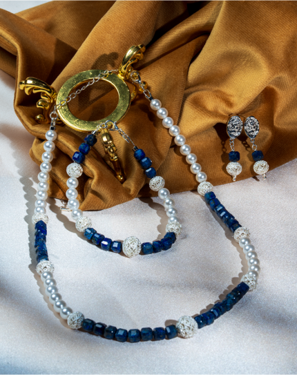 ست زنانه شوکا با ترکیب لاجورد طبیعی سرمه‌ای و مروارید سفید مصنوعی. شامل گردنبند، دستبند و گوشواره. مناسب استایل رسمی و مهمانی.