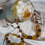 ست سیترین و عقیق طبیعی شوکا با ترکیب رنگ‌های زرد، طلایی و قهوه‌ای، زیورآلاتی شیک شامل گردنبند، دستبند و گوشواره با جلوه‌ای گرم و لوکس.