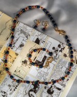 ست یاقوت و مروارید سرمه‌گون شوکا با ترکیب بی‌نظیر مرواریدهای طبیعی آبی تیره و یاقوت‌های زرشکی، طراحی دست‌ساز و جزئیات طلایی. گزینه‌ای لوکس و چشم‌گیر برای مهمانی، استایل رسمی و هدیه خاص.